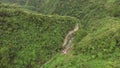 Rocky mountain rugged winding road replete with natural grown trees.