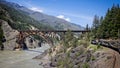 Rocky Mountaineer luxury train approaching iron bridge along the Fraser River in the Rocky Mountains, British Columbia, Canada