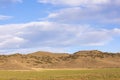 Rocky mountains behind a green field