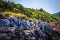 Rocky mountains covered with green grass on clear summer day. Landscape of hilly mountains in a tropical area. Royalty Free Stock Photo