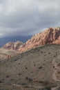 Rocky outcrop and desert plain with cloudy sky.