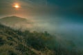 Rocky peak with daybreak. Full moon night ends and sun appeared Royalty Free Stock Photo