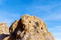 Textured Golden Rocky Mountain peak under a blue sky