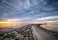 Rocky pier at the entrance to the harbor at sunset Royalty Free Stock Photo