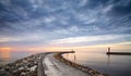 Rocky pier at the entrance to the harbor at sunset Royalty Free Stock Photo