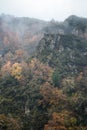 Rocky promontory rising among leafy autumn forests