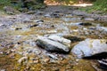 Rocky river in the mountains near the Shypit waterfall in Carpathian mountains. Large stones in the middle of a shallow river.