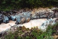 A rocky river in the mountains with turbid water