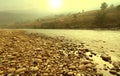 Rocky riverside with gloden sunrise in the morning Royalty Free Stock Photo