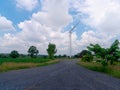 Rocky road to wind turbine with cloudy blue sky in urban Royalty Free Stock Photo