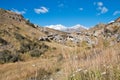 Rocky hillsides and dry meadows afford a glimpse of distant mountains