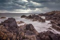 Rocky scottish coastline on a stormy day. Dark clouds and dark rocks looking out to sea