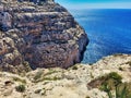 Rocky sea coast. A picture of mussels growing on the beach. Sharp gray rocks against the sea. Seascape - transparent, blue, Royalty Free Stock Photo