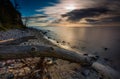 Rocky sea shore with driftwood at sunrise. Beautiful seascape Royalty Free Stock Photo