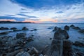 Rocky seascape at sunrise with waves flowing over harsh granite rocks