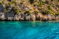 Rocky steep coast and azure water. Sunny weather Royalty Free Stock Photo