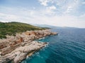 Rocky seaside near Veslo camping in Montenegro. Azure blue water, white waves hitting the rocks, sunny summer day