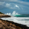 Rocky shore braves crashing waves, a testament to natures power