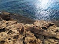 Rocky shore with clear blue water. Seashore with large weathered boulders. Mediterranean Sea coast, Cyprus. Royalty Free Stock Photo