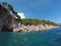 Rocky shore, pine trees grow on the rocks,blue sky, sea