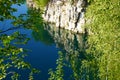 Rocky shore stone quarry with grass and shrubs. water is dark blue with reflection of stones. lake after the development of the