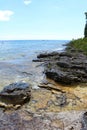 The rocky shoreline of Lake Michigan with people swimming in the distance at Cave Point County Park in Wisconsin Royalty Free Stock Photo