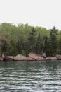 The rocky shoreline of Lake Superior lined with a variety of trees in a dense forest in Bayfield, Wisconsin Royalty Free Stock Photo