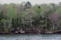 The rocky shoreline of Lake Superior lined with a variety of trees, including evergreens and Birch, in a dense forest in Wisconsin Royalty Free Stock Photo