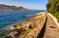 Rocky shoreline landscape of Saint-Jean-Cap-Ferrat resort town with sightseeing path on Cap Ferrat cape in France