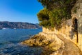 Rocky shoreline landscape of Saint-Jean-Cap-Ferrat resort town with sightseeing path on Cap Ferrat cape in France