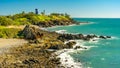 Rocky shoreline at Slade Point with a water tower in the background, Queensland, Australia