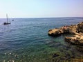 The rocky shores of the old town of Rovinj, Croatia along the Adriatic Sea. Locals and tourists are swimming Royalty Free Stock Photo