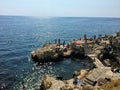 He rocky shores of the old town of Rovinj, Croatia along the Adriatic Sea. Locals and tourists are swimming Royalty Free Stock Photo