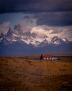 Rocky snowy mountain peaks with the sun rising behind and red clouds. Fitz Roy in Argentina