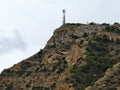 rocky summit hosting communication tower overlooking coast and valley under cloudy Royalty Free Stock Photo