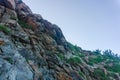 Rocky terrain with steep rough cliffs and scattered weeds. Mountain limestone rocks texture Royalty Free Stock Photo