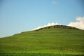 Rocky top of a high hill in the steppe overgrown with grass