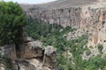 Rocky valley under a ledged cliff of gray rocks