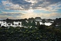 Rocky volcanic coastline with sunset, Pico island