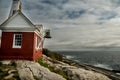 Rocky wild coast of the Atlantic Ocean. USA. Maine. A small lighthouse house on the rocks