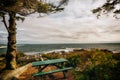 Rocky wild coast of the Atlantic Ocean. USA. Maine. A small lighthouse house among the trees and a resting place