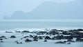 Rockyshore with soft scene of wave of the sea cause of it`s raining Royalty Free Stock Photo