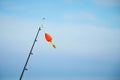 A rod with float bobber at the top in natural setting with sea on background. Royalty Free Stock Photo