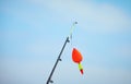 A rod with float bobber at the top in natural setting with sea on background. Royalty Free Stock Photo