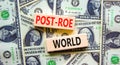 Roe vs Wade post-Roe world symbol. Concept words Post-Roe world on wooden blocks on a beautiful background from dollar bills.