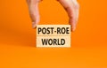 Roe vs Wade post-Roe world symbol. Concept words Post-Roe world on wooden blocks on a beautiful orange background. Businessman