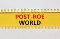 Roe vs Wade post-Roe world symbol. Concept words Post-Roe world on yellow paper on a beautiful white background. Business and Roe