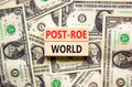 Roe vs Wade post-Roe world symbol. Concept words Post-Roe world on wooden blocks on a beautiful background from dollar bills.