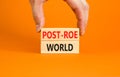 Roe vs Wade post-Roe world symbol. Concept words Post-Roe world on wooden blocks on a beautiful orange background. Businessman