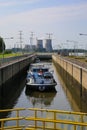 View on lock sluice at river Maas with cargo ship, blurred towers of RWE power station background